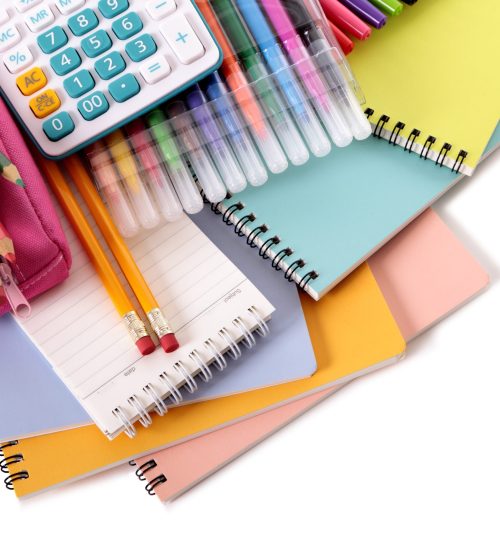 Various school supplies including notebooks, calculator and pink pencil case isolated against a white background
